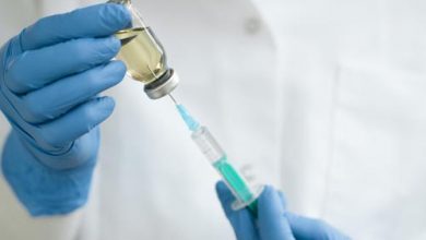 vista-frontal-do-medico-usando-a-seringa-para-vacina_