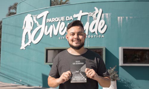As crônicas da juventude Cada pessoa tem a sua própria história de juventude, mas muitas das vivências pelas quais passamos se parecem com as de outros jovens também. Foi o caso do autor, que narra nas 21 crônicas do livro os principais momentos dessa fase, do ensino médio até a vida adulta. Em textos como “Um grande salto”, “Jovem aprendiz” e “Vida de estagiário”, são retratadas passagens como a saída da casa dos pais e como lidar com o início da carreira profissional. As crônicas também traduzem a relação entre o jovem e a cidade. No texto de abertura, “Salve, São Bernardo”, uma ode a tudo o que torna o lugar tão especial, como o fato de ser uma cidade grande com clima de interior. Já em textos como “O escadão do Sonda”, “Sobre o rolê” e “Fetiche em cômodo”, o autor faz uma análise pessoal e detalhada sobre os principais rolês da cidade (como festas e baladas), frequentados por milhares de jovens. A pandemia tem sido um momento de teste em especial para os mais novos e não passou despercebida no livro. A crônica “Triste adeus à minha jovem-juventude” fala sobre como o jovem lida com a quarentena. E em um dos textos finais do livro, “Carta aos 15”, o autor faz uma viagem no tempo e escreve uma mensagem do futuro para o seu “eu” de 15 anos de idade, a fim de trazer a experiência e os aprendizados adquiridos durante todo esse tempo. “Historicamente, o jovem já não vivia um bom momento antes da pandemia, tendo que lidar com o desemprego e questões de saúde como ansiedade e depressão. Hoje, temos muita dificuldade em olhar para frente e enxergar uma perspectiva positiva do futuro. Uma das poucas coisas que podemos fazer agora é ler, e espero que o livro possa divertir e fazer com que todos relembrem os melhores momentos da juventude com carinho”, finaliza. O projeto foi viabilizado pela Lei Federal Aldir Blanc, criada durante o período da pandemia para apoiar a classe artística do país. O livro foi um dos 27 vencedores do edital de Publicações, organizado pela Secretaria de Cultura e Juventude de São Bernardo do Campo (SP).