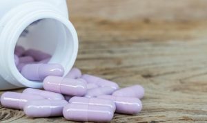 Bottle drug purple capsule on wood table