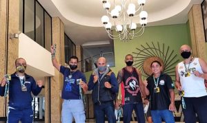 Anderson Reis levanta medalha de Ouro ao lado de outros atletas.