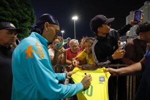 Raphinha atende aos torcedores e assina camisa da Seleção Brasileira para um deles - Créditos: Rafael Ribeiro/CBF